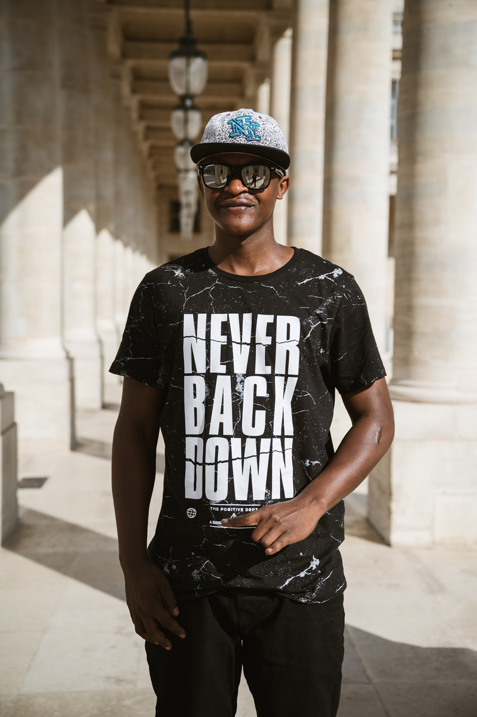 Jeune homme noir portant un T-Shirt avec des inscriptions en lettres capitales