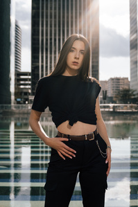 Un rayon de soleil illumine une jeune femme devant le bassin du quartier de La Défense à Paris