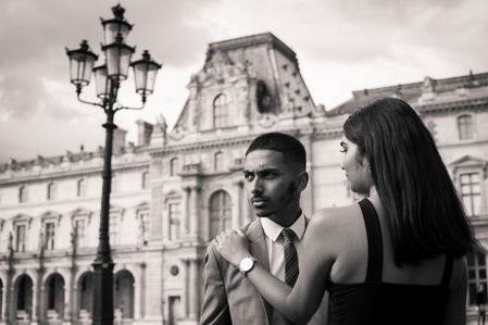 Photo noir et blanc d'un couple élégant dans la cours du Musée du Louvre à Paris