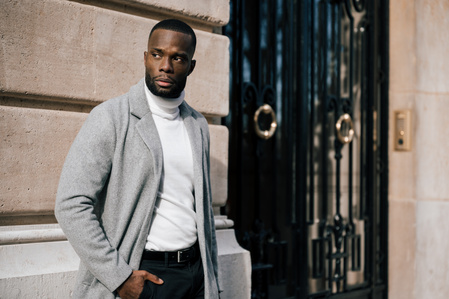 Jeune homme black devant une porte des quartiers chics