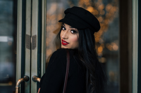 Jeune femme avec du rouge à lèvres qui se retourne devant une porte