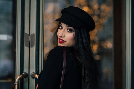 Jeune femme avec du rouge à lèvres qui se retourne devant une porte