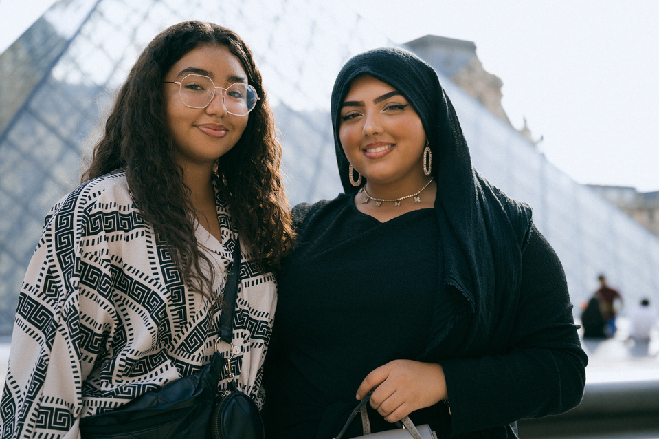 Deux amies proches devant la pyramide du Louvre