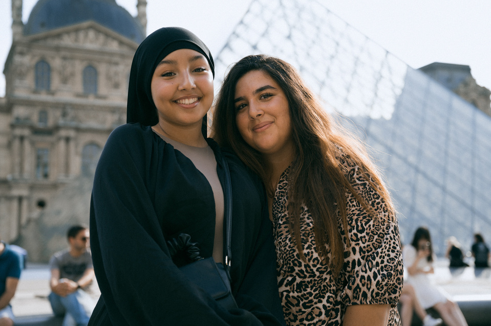 Deux amies proches devant la pyramide du Louvre