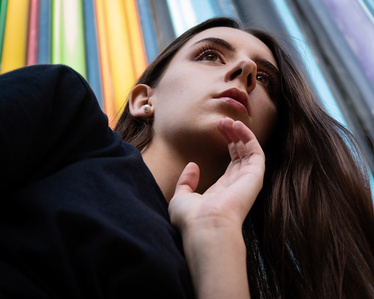 Portrait en contre-plongée d&amp;#x27;une jeune femme brune devant un fond multicolore