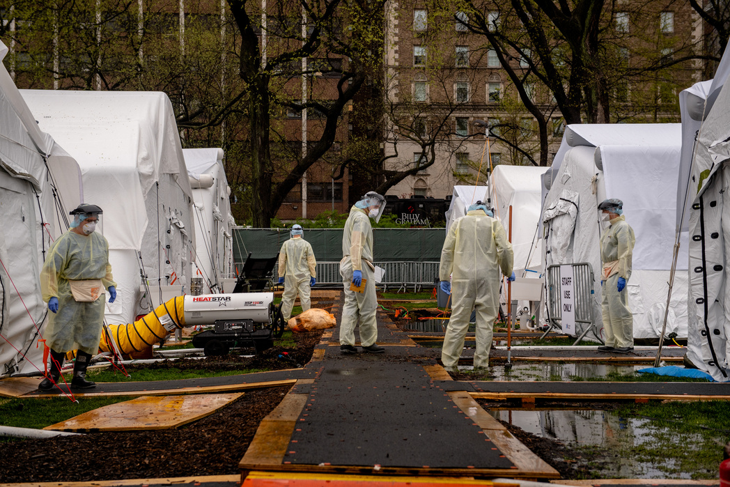 NEW YORK, NEW YORK– APRIL 13, 2020: Employees at Samaritan's Purse field hospital work to secure tents in the face of rain and strong winds. The field hospital is dedicated to Covid-19 patients in Central Park with Mount Sinai Hospital on Monday morning.