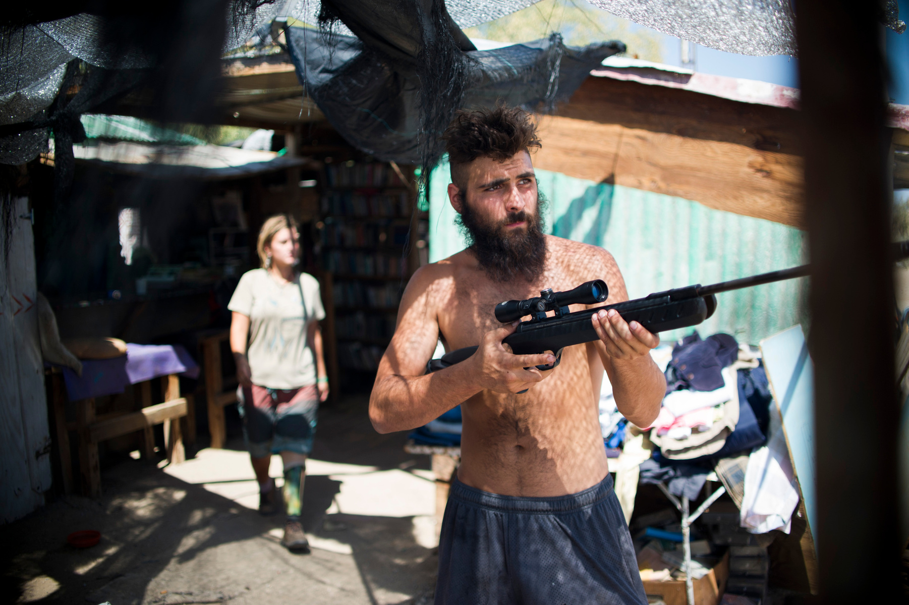 Caveman, right, and Cornelius shooting guns at the Library in Slab City.