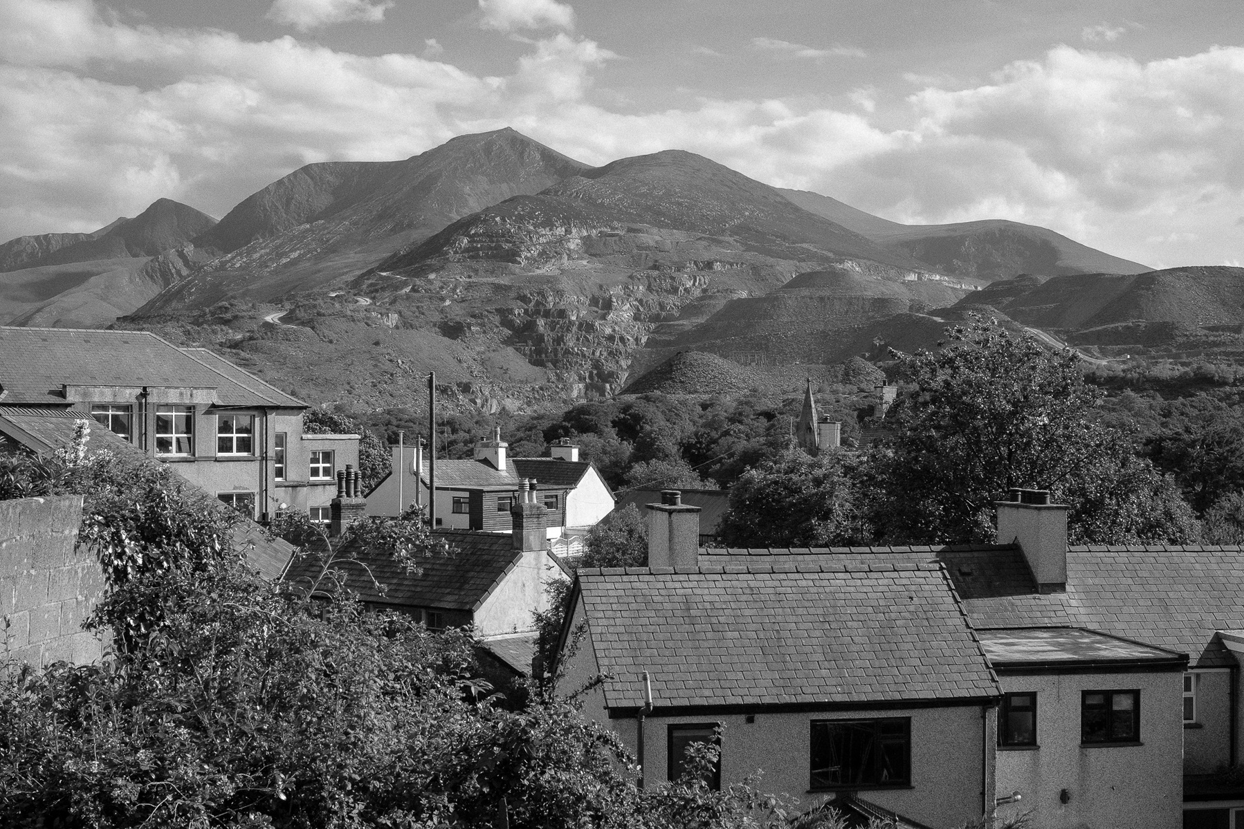Black and white photograph of the Penrhyn Slate Quarry in North Wales. In the foreground the houses of the Carneddi in Bethesda can be seen.