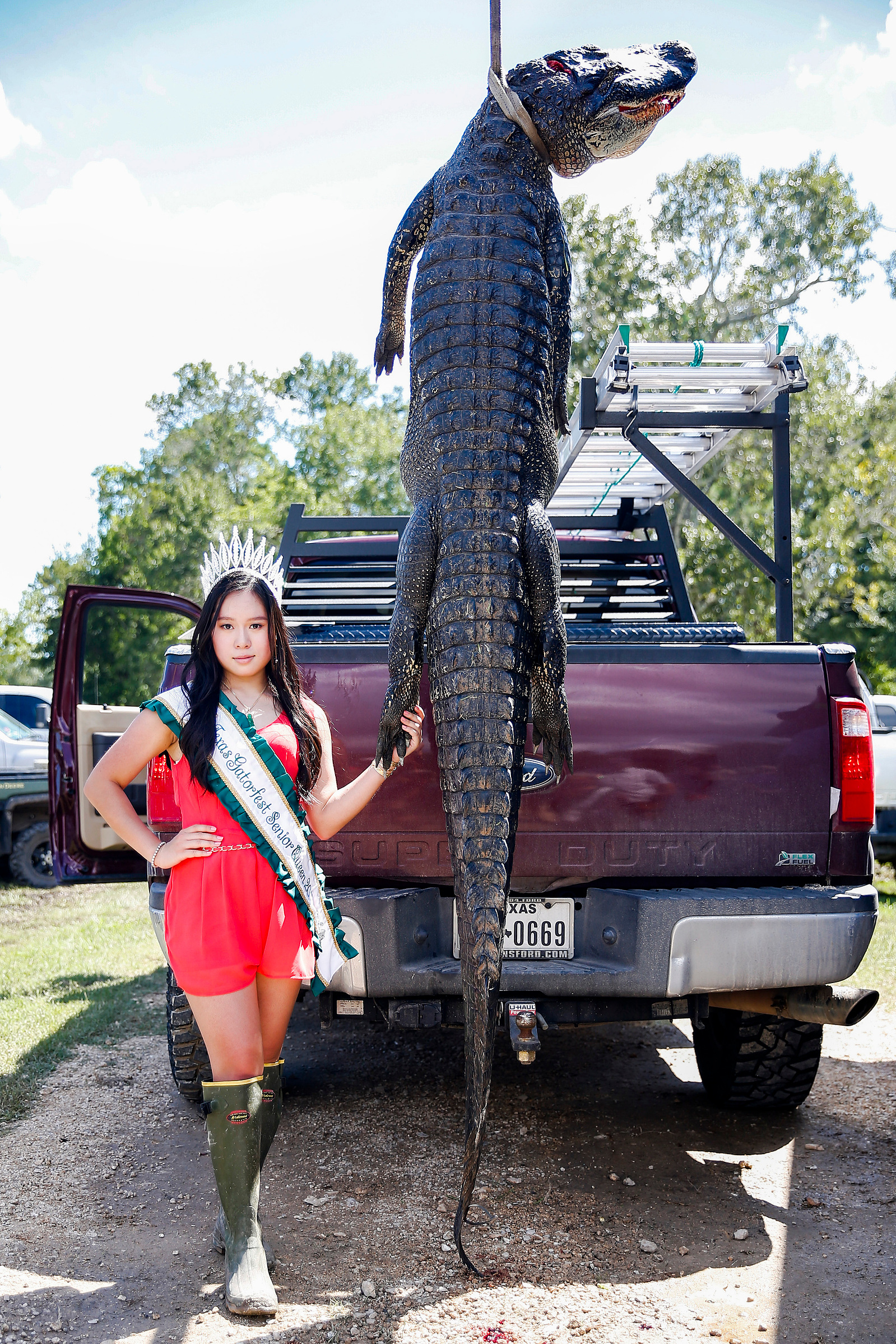 Texas Gatorfest Senior Queen Tracy Ly, 16, poses for a portrait with an alligator caught during the Great Texas Alligator Roundup at the Texas Gatorfest Saturday Sept. 15, 2018 in Anahuac.