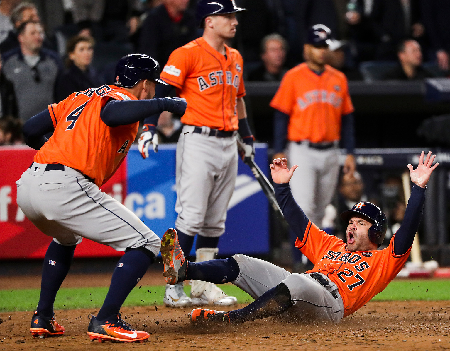Houston Astros center fielder George Springer (4) and second baseman Jose Altuve (27) celebrate as Altuve scores on Yuli Gurriel's 3-run double off New York Yankees relief pitcher David Robertson during the sixth inning of Game 4 of the ALCS at Yankee Sta