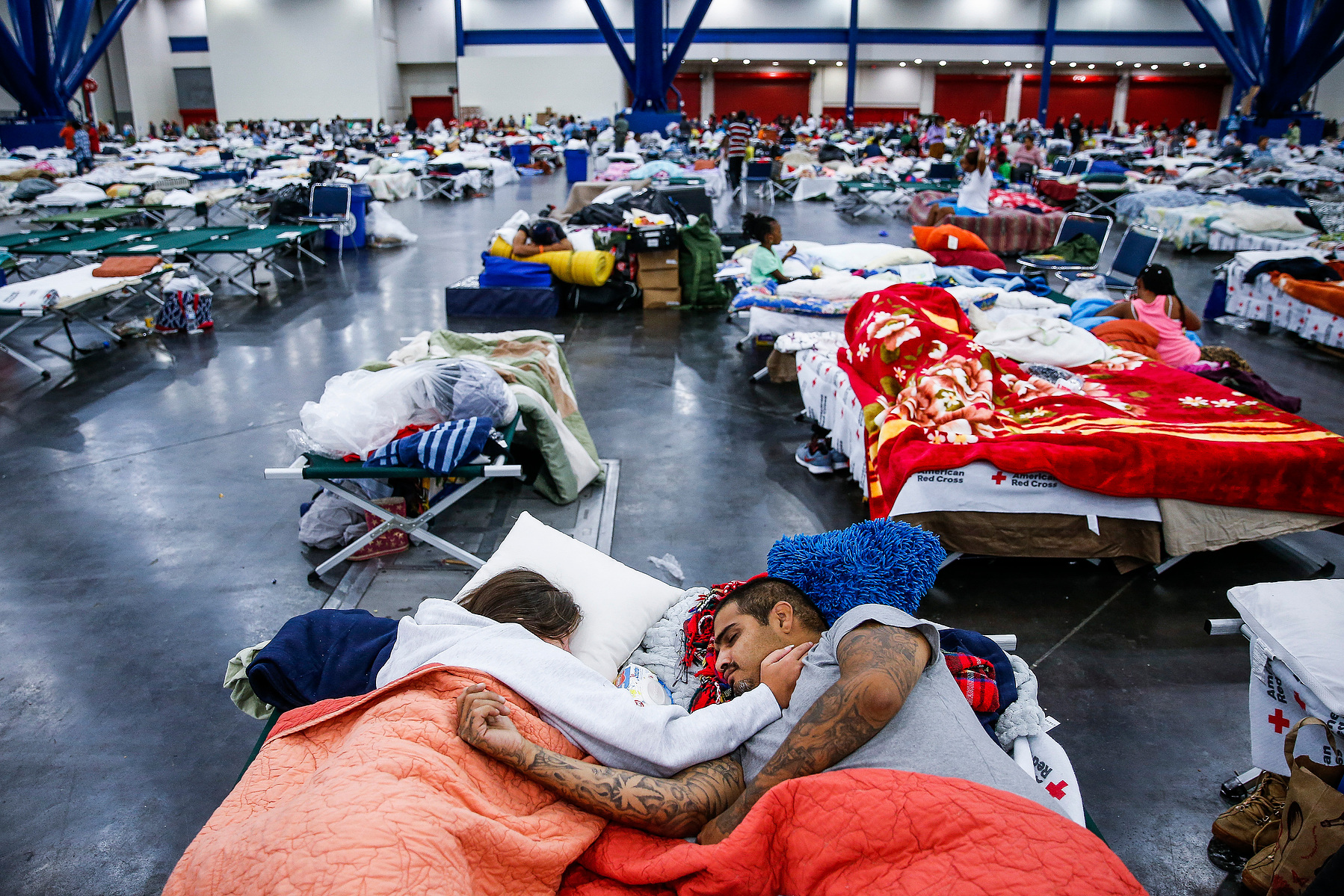 Tammy Dominguez, left, and her husband, Christopher Dominguez, sleep on cots at the George R. Brown Convention Center where nearly 10,000 people are taking shelter after Tropical Storm Harvey Wednesday, Aug. 30, 2017 in Houston. They have been at the shel