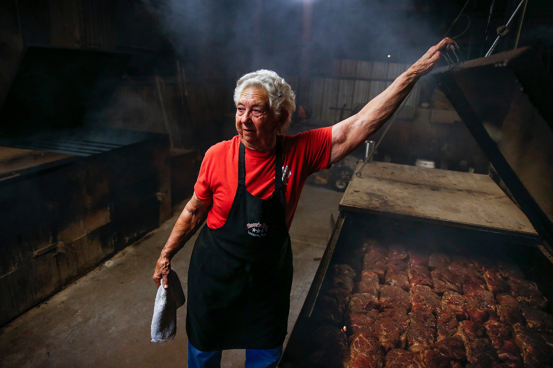 Snow's BBQ 82-year-old pit master, Norma "Tootsie" Tomanetz, closes the top of a bar-b-cue pit holding pork steak early Saturday, March 24, 2018 in Lexington.