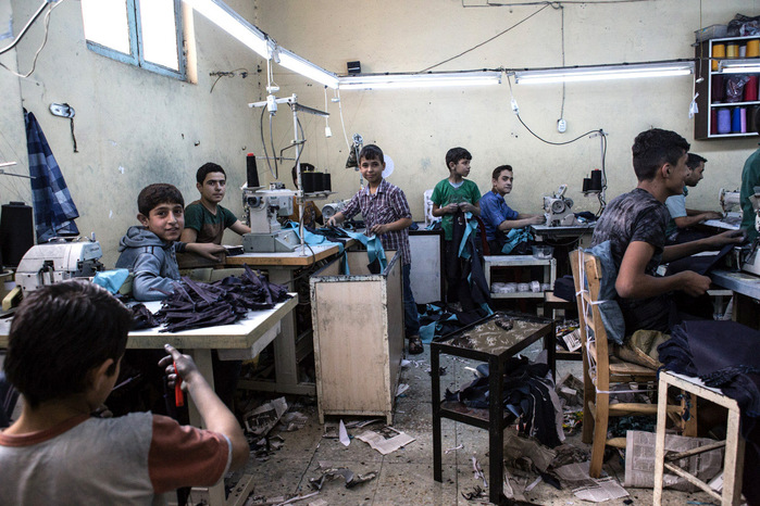 Bambini siriani lavorano per la produzione di pantaloi jeans per adulti in un laboratorio tessile turco nell'area industriale di Gaziantep, Turchia. 14 Maggio 2016.