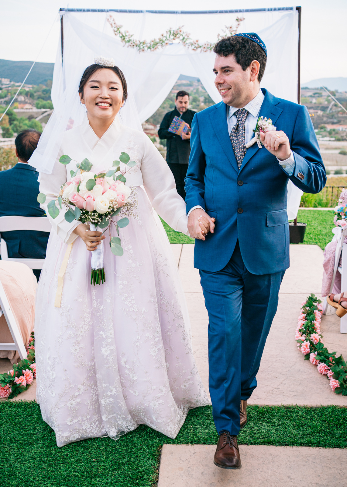 smiling bride and groom dance back down the aisle