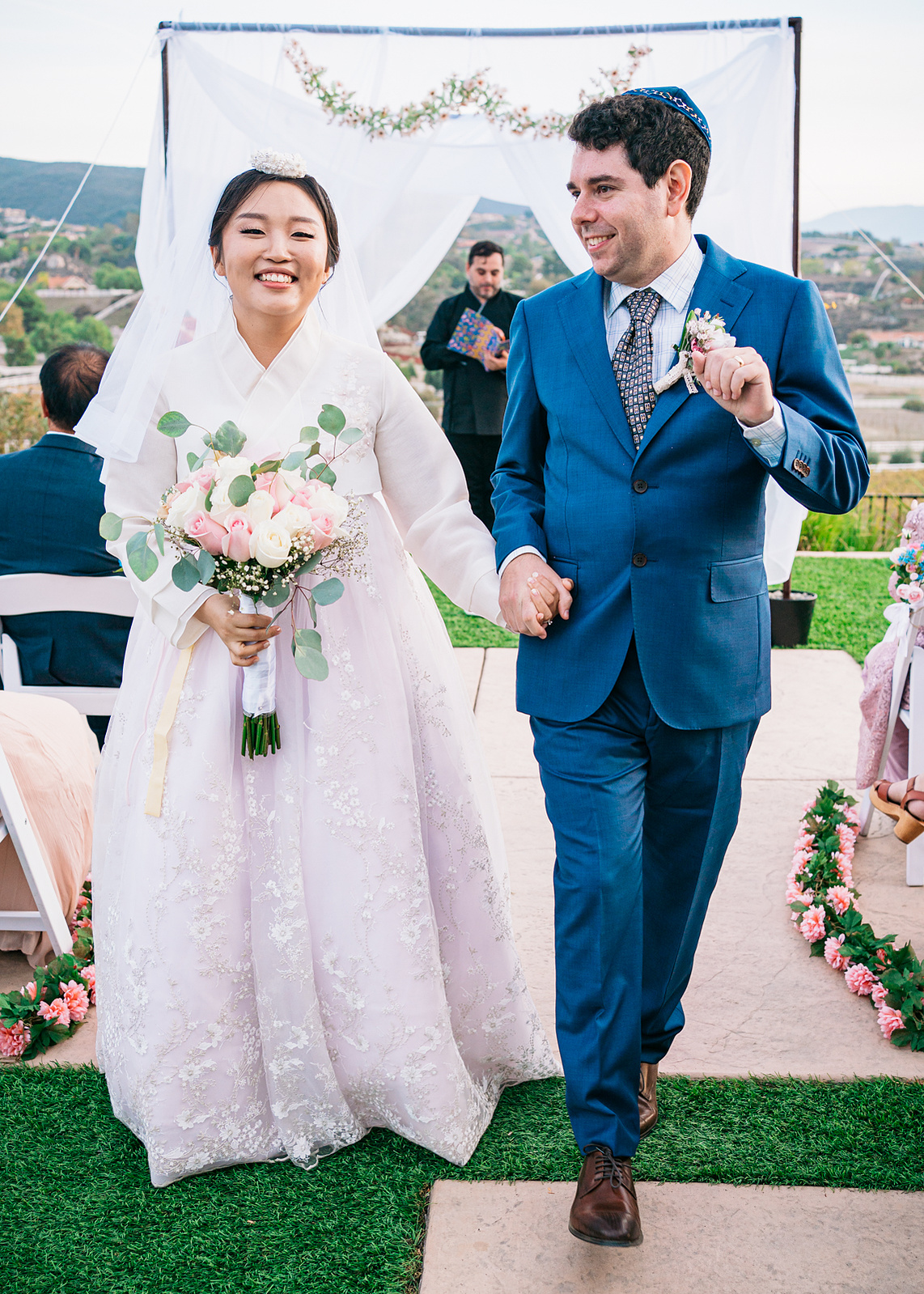 smiling bride and groom dance back down the aisle