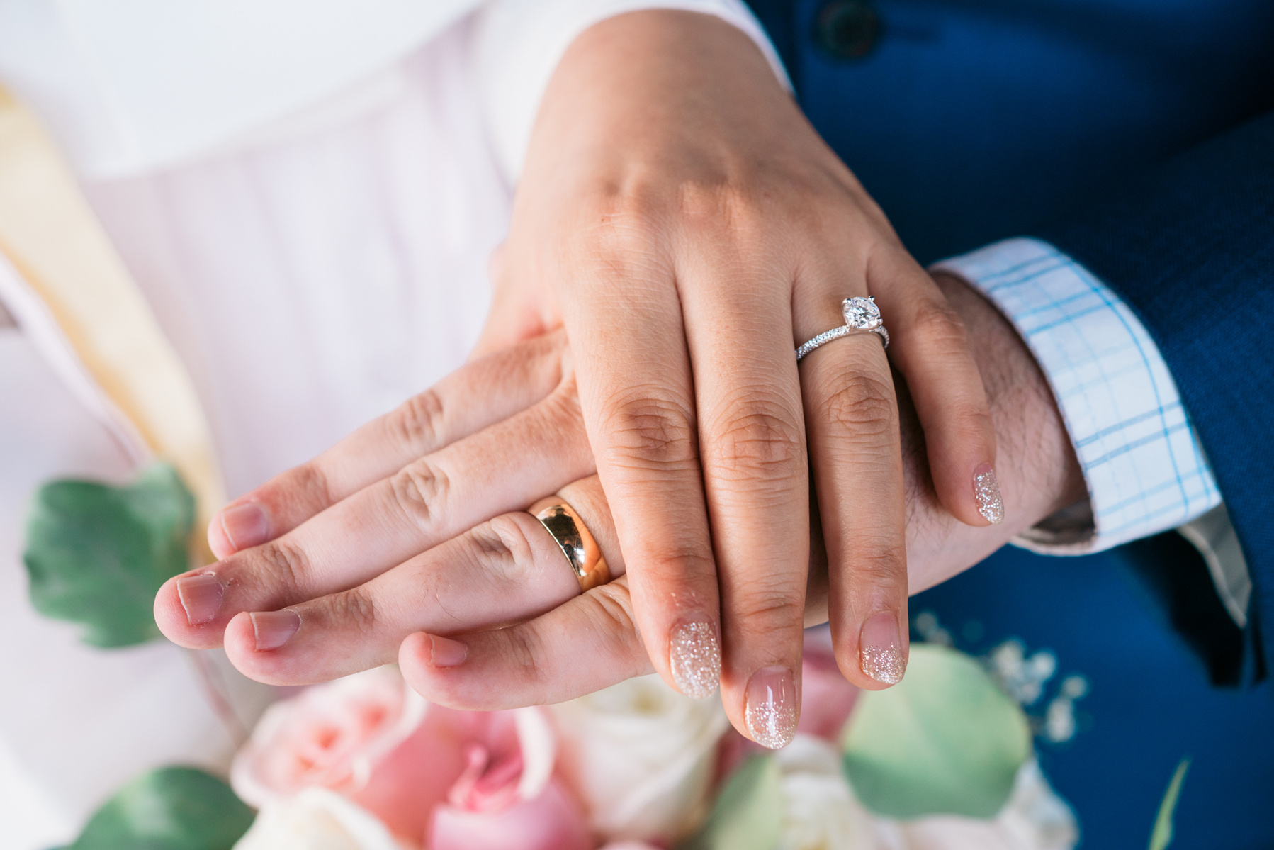 bride and grooms hands with their wedding bands rings 
