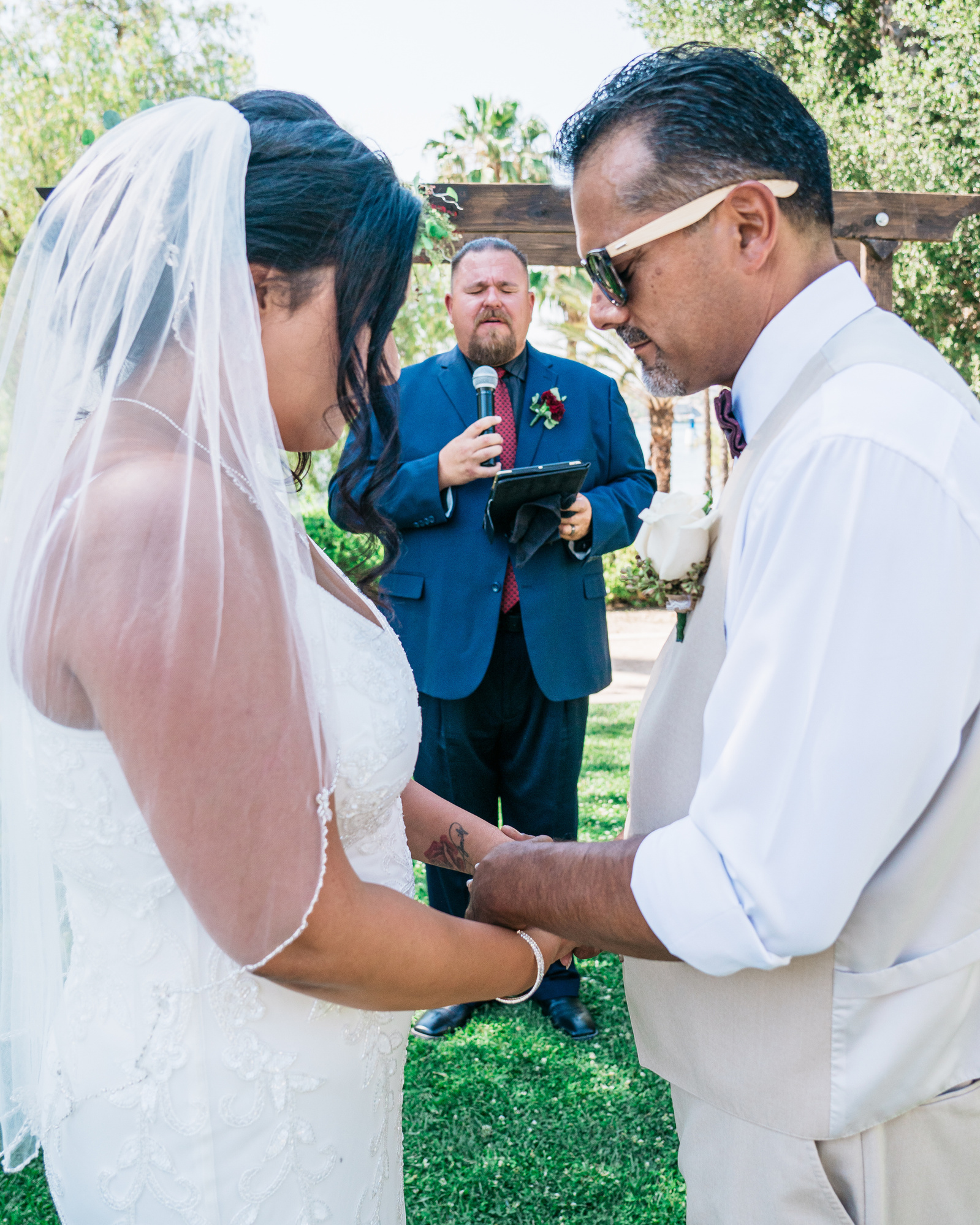 pastor leads the bride and groom hand in hand in prayer