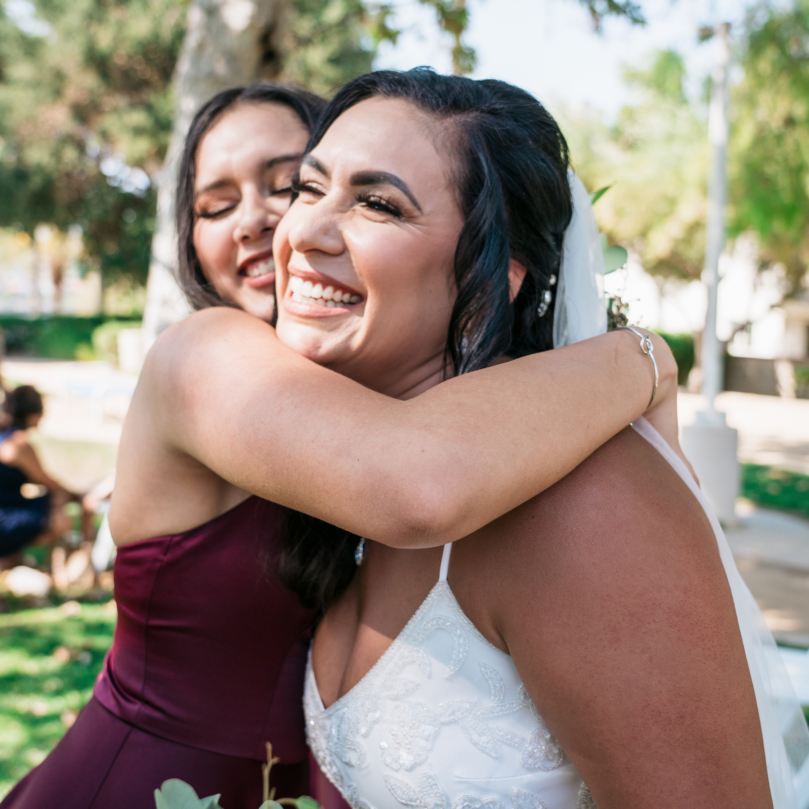 step daughter hugs smiling bride step mother 