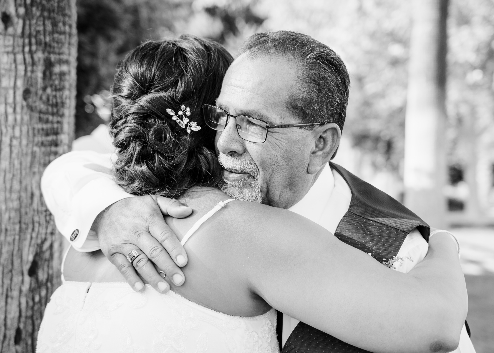 black and white father of the bride embraces his daughter