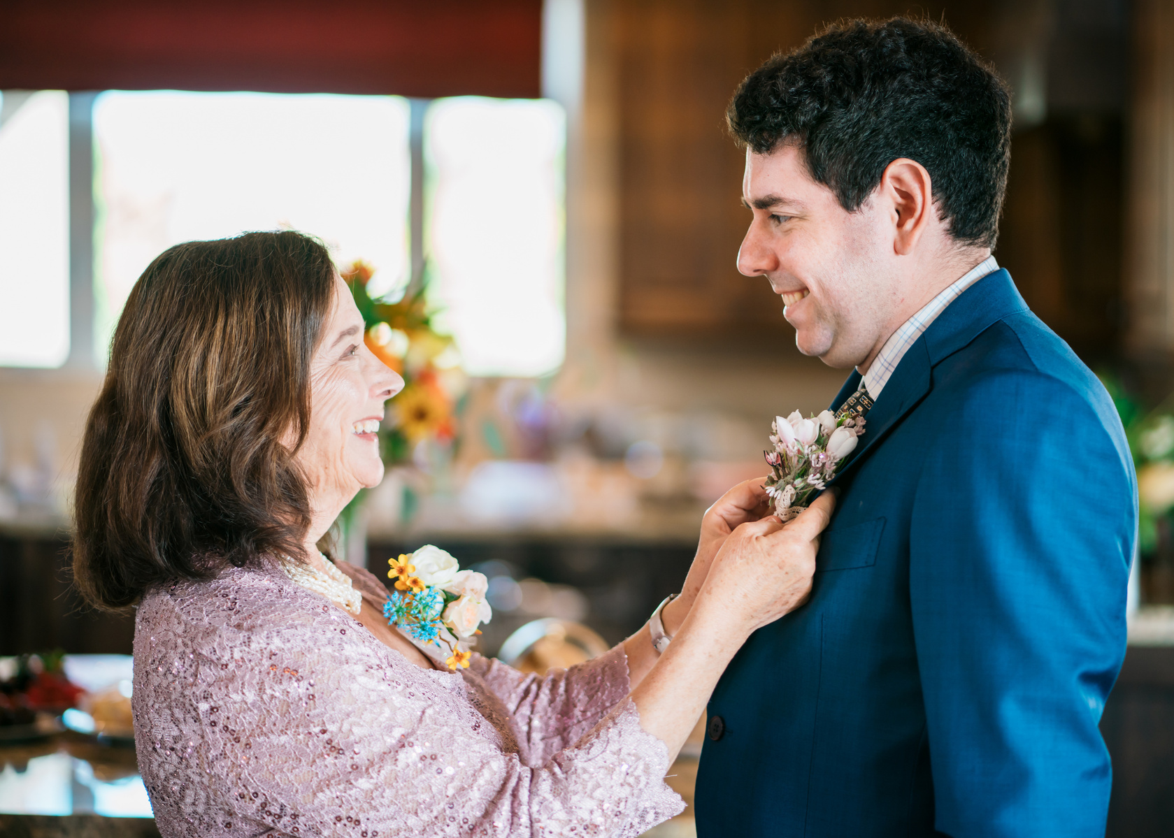 eye to eye a mother helps her son with his boutonniere 