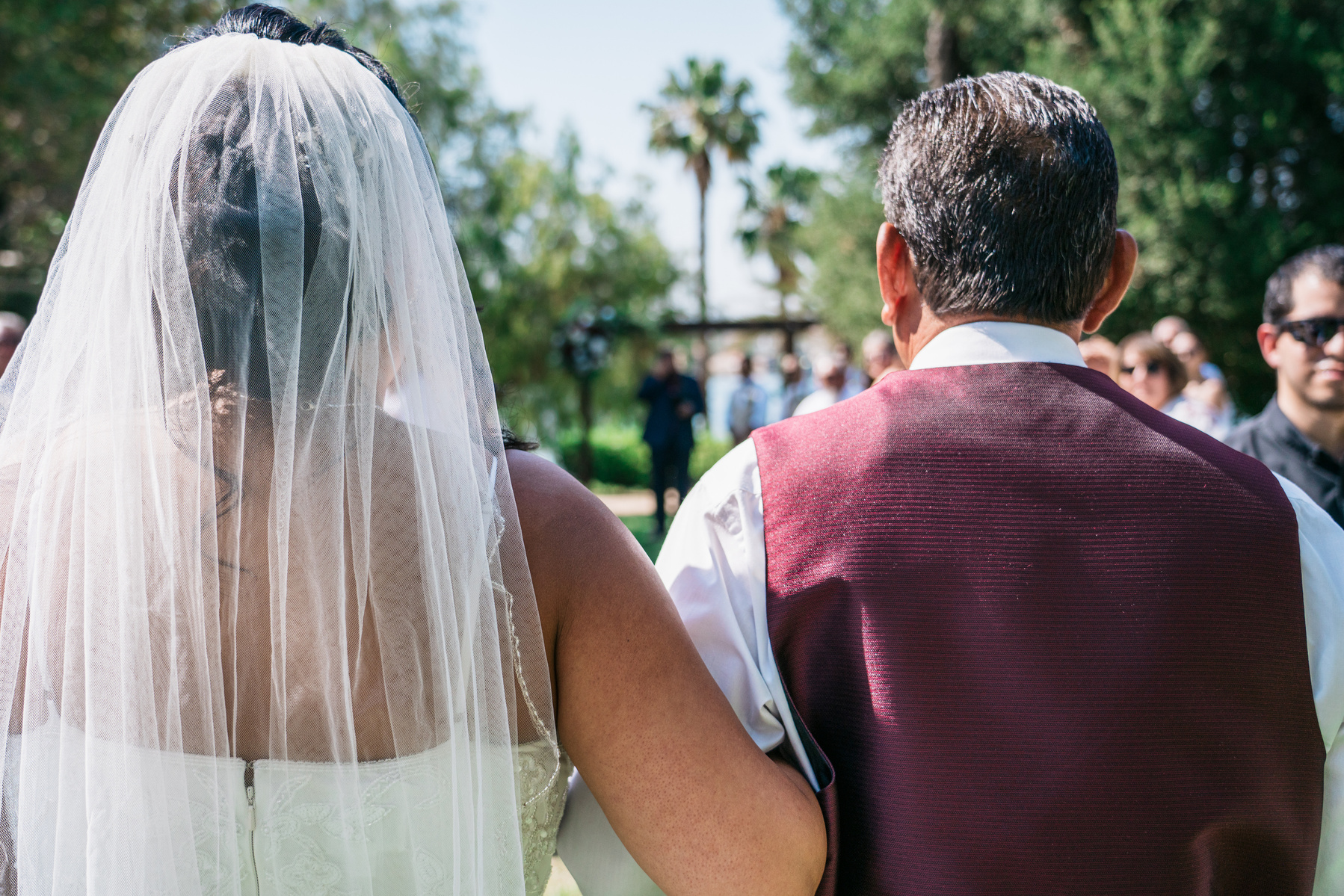 over the shoulder of bride in veil and her father