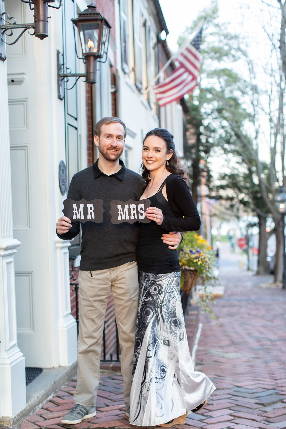 Newly wed couple on an historic street holding signs reading "Mr" and "Mrs"