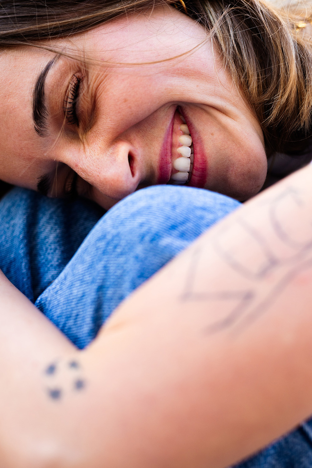 Jeune femme tatouée qui sourit.