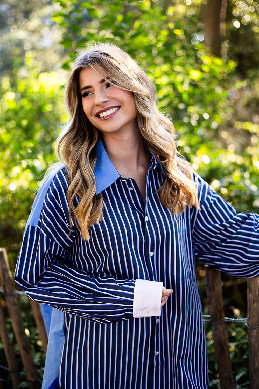 Jeune femme en chemise qui sourit.