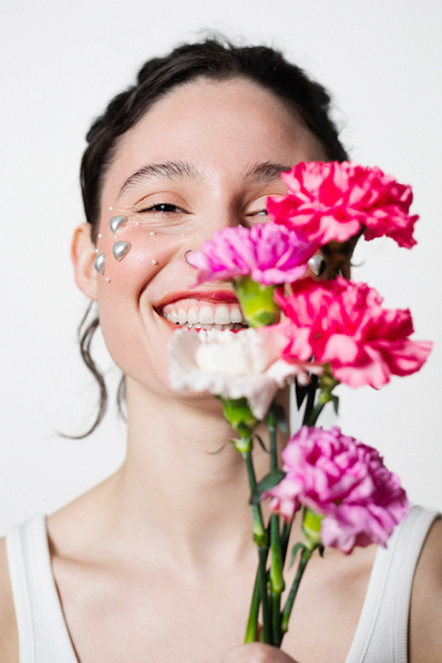 Portrait artistique d'une femme en studio, lumière douce et fleurs roses – Photographe à Toulouse