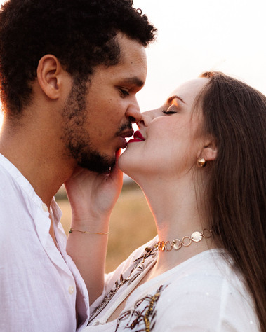 Un couple s'embrasse tendrement de profil.