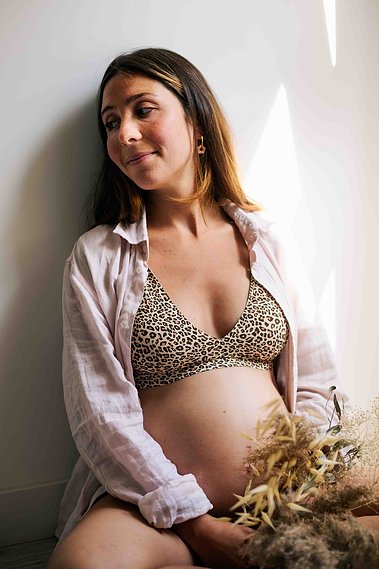 Femme enceinte qui tient un bouquet de fleurs séchées lors d’une séance photo grossesse  à Toulouse