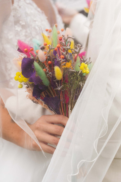 Une mariée tient un magnifique bouquet de fleurs, photographié par Ines Pochelu, photographe à Toulouse