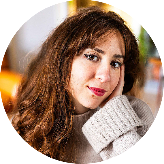 Une jeune femme sourit tendrement en se tenant la tête avec sa main.