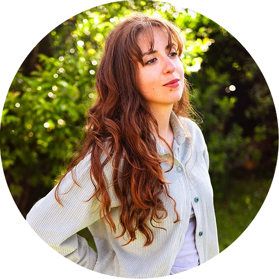 La photographe Ines Pochelu sourit tranquillement dans un jardin à Toulouse.