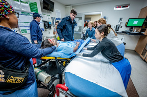 Emergency response team surrounds a simulated patient during a Mass Casualty Incident drill at Texas Health Presbyterian Hospital Dallas -  multiple disciplines working in coordinated trauma response training.
