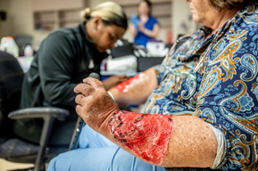 Close-up of simulated trauma wounds applied during moulage preparation for a Mass Casualty Incident drill at Texas Health Presbyterian Hospital Dallas - realistic injury makeup used to train emergency response teams.
