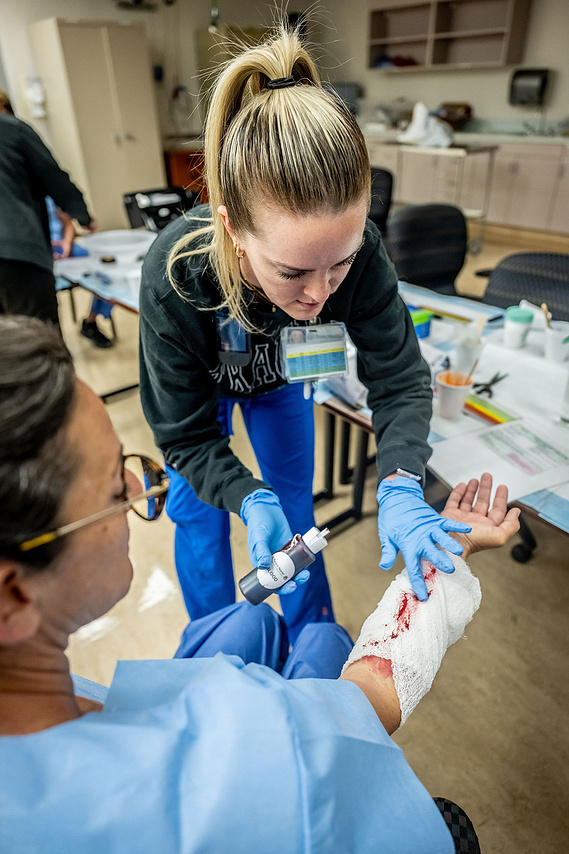 Emergency nurse treats a simulated hand wound during a Mass Casualty Incident drill at Texas Health Presbyterian Hospital Dallas - documenting hands-on trauma response training in action.
