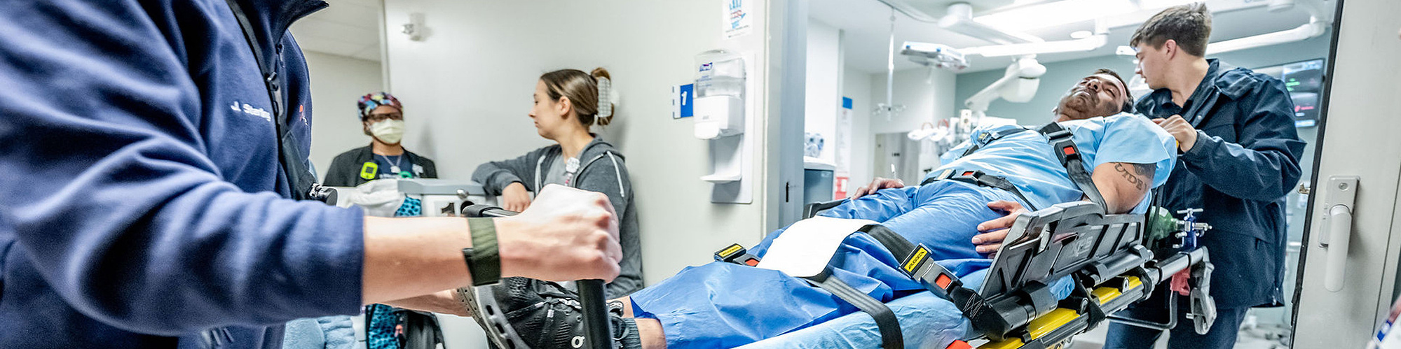 Cinematic wide-angle view of an emergency response team rushing a simulated patient through the ER during a Mass Casualty Incident drill at Texas Health Presbyterian Hospital Dallas - captured by Dallas healthcare photographer Aggie Brooks.
