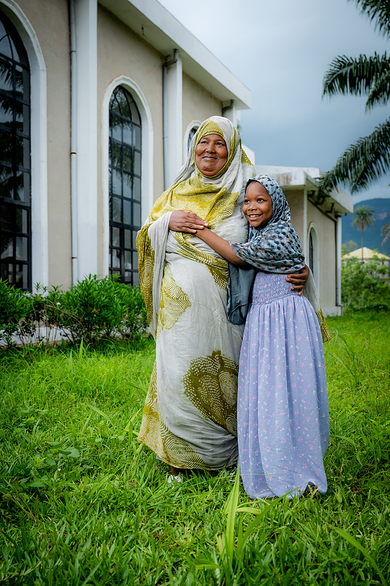 Mother and daughter embracing outside the Sacré Coeur medical clinic in Guinea, West Africa.
