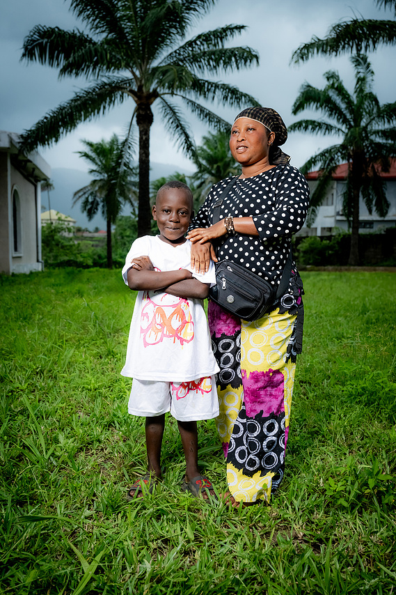 Mother and child standing together outside the Sacré Coeur medical clinic in Guinea, West Africa.