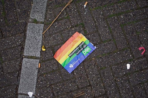 Printed rainbow flag fallen on the ground during the Amsterdam Gay Pride in 2015, with the caption 