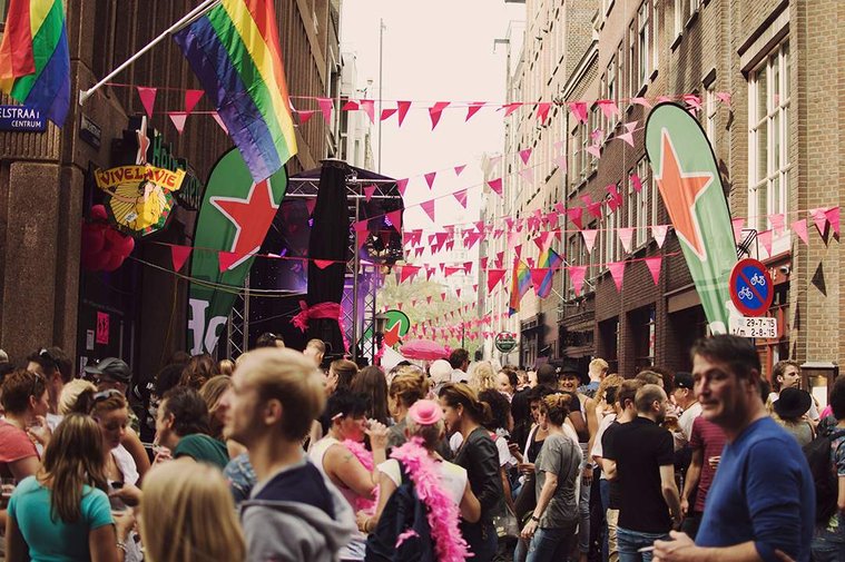 Groups of people and rainbow colored street decorations during the Amsterdam Gay Pride in 2015.
Gruppen von Menschen und regenbogenfarbene Straßendekorationen auf der Amsterdam Gay Pride 2015.