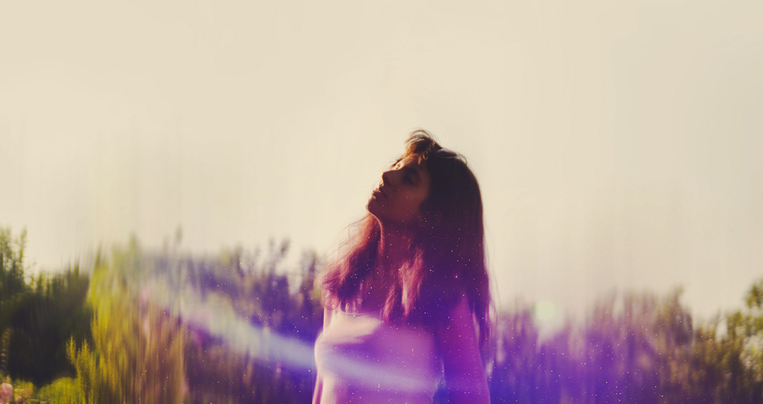 Meditative dreamy girl in garden looking up at sky
