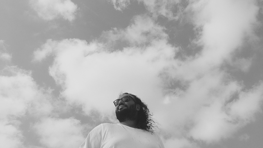 Black and white photograph of young man against the sky, taken with iPhone SE (1st gen)