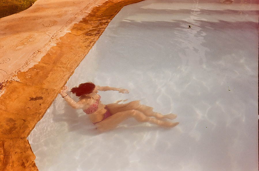 Analog photograph of girl diving under water