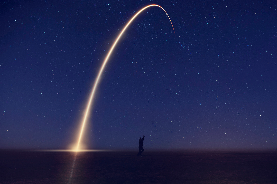 Conceptual montage of man reaching for the stars with night sky