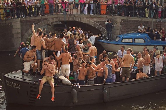 Boat full of male celebrators during Amsterdam Gay Pride / Canal Parade in 2015.
Boot voller männlicher Feiernder während der Amsterdamer Gay Pride / Canal Parade im Jahr 2015.