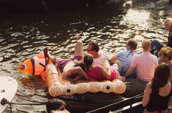 Cuddling group of friends on raft during Amsterdam Gay Pride / Canal Parade in 2015.
Kuschelnde Gruppe von Freunden auf einem Floß während der Amsterdam Gay Pride / Canal Parade im Jahr 2015.
