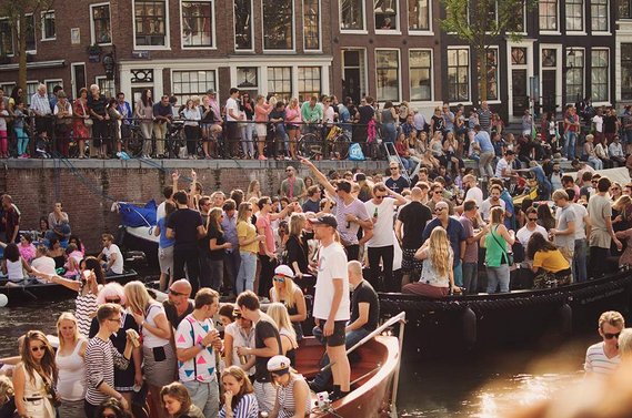 Crowds of people on boats during Amsterdam Gay Pride / Canal Parade in 2015.
Menschenmassen auf Booten während der Amsterdam Gay Pride / Canal Parade im Jahr 2015.