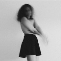 Black and white self portrait of young female in black skirt and nude upper body